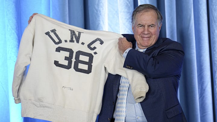 Dec 12, 2024; Chapel Hill, NC, USA;   North Carolina Tar Heels new head coach Bill Belichick holds up the sweatshirt worn by his father when he was an assistant coach at New North Carolina Tar Heels new at Loudermilk Center for Excellence. Mandatory Credit: Jim Dedmon-Imagn Images