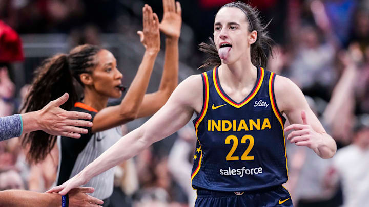 Indiana Fever guard Caitlin Clark (22) high-fives fans after scoring a 3-pointer Saturday, June 14, 2025, during a game between the Indiana Fever and the New York Liberty at Gainbridge Fieldhouse in Indianapolis.