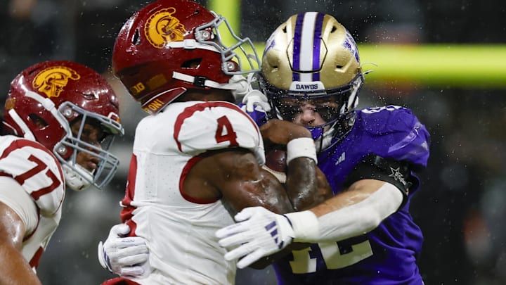 Huskies linebacker Carson Bruener tackles USC running back Woody Marks during the second quarter, one of his game-high 12.