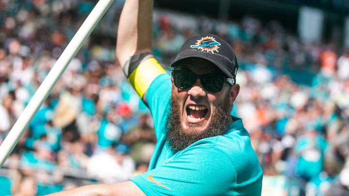 A member of the Miami Dolphins game day staff cheers while carrying a flag after the Dolphins scored