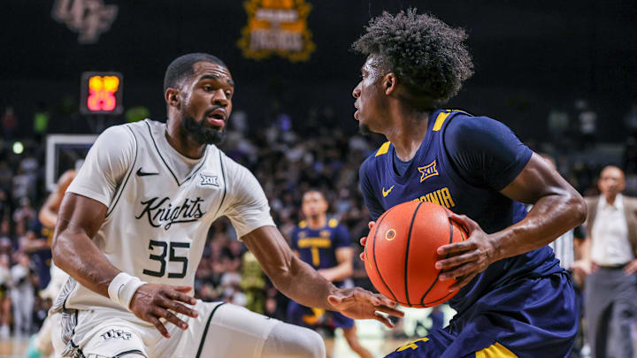 Feb 14, 2026; Orlando, Florida, USA; UCF Knights forward Devan Cambridge (35) defends West Virginia Mountaineers guard Honor Huff (3) during the first half at Addition Financial Arena. Mandatory Credit: Mike Watters-Imagn Images