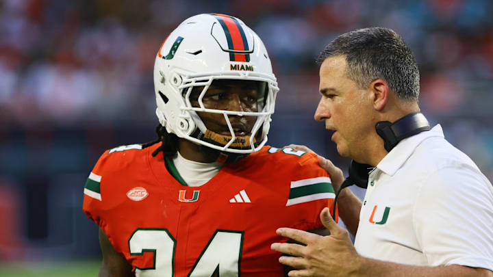 Sep 7, 2024; Miami Gardens, Florida, USA; Miami Hurricanes head coach Mario Cristobal talks to Miami Hurricanes linebacker Malik Bryant (24) during the second quarter at Hard Rock Stadium. Sep 7, 2024; Miami Gardens, Florida, USA; Miami Hurricanes head coach Mario Cristobal talks to Miami Hurricanes linebacker Malik Bryant (24) during the second quarter at Hard Rock Stadium.