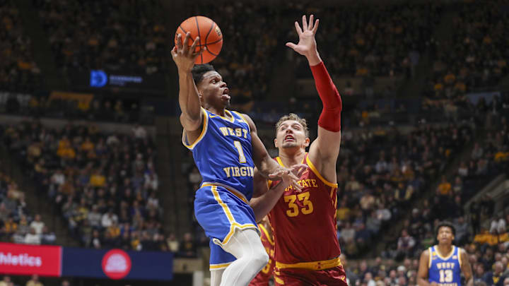 Jan 18, 2025; Morgantown, West Virginia, USA; West Virginia Mountaineers guard Joseph Yesufu (1) shoots against Iowa State Cyclones forward Brandton Chatfield (33) during the first half at WVU Coliseum. Mandatory Credit: Ben Queen-Imagn Images