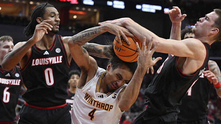 Nov 22, 2024; Louisville, Kentucky, USA;  Louisville Cardinals forward James Scott (0) and forward Noah Waterman (93) battle Winthrop Eagles forward Kelton Talford (4) for a rebound during the first half at KFC Yum! Center.