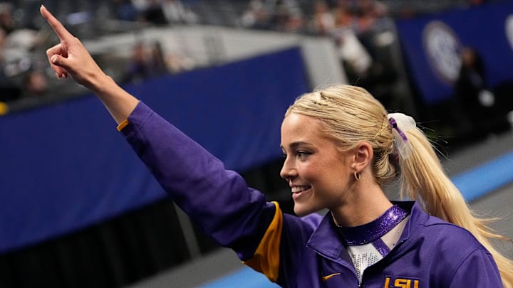 Then LSU gymnast Livvy Dunne walks with teammates to a competition area and gestures to fans during Session 2 of the SEC Gymnastics Championship.
