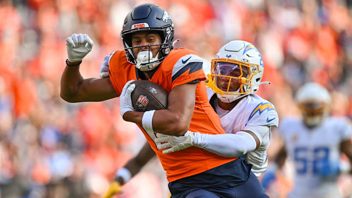 DENVER, CO - OCTOBER 13: Broncos wide receiver Devaughn Vele (17) runs the ball as Chargers cornerback Tarheeb Still (29) tries to tackle him, during a game between the Denver Broncos and the Los Angeles Chargers at Empower Field at Mile High in Denver, CO on October 13, 2024. 