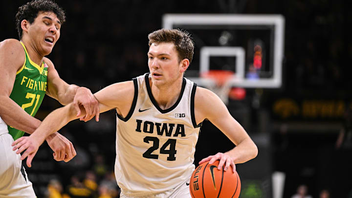 Feb 19, 2025; Iowa City, Iowa, USA; Iowa Hawkeyes forward Pryce Sandfort (24) controls the ball as Oregon Ducks forward Brandon Angel (21) defends during the second half at Carver-Hawkeye Arena. Mandatory Credit: Jeffrey Becker-Imagn Images Feb 19, 2025; Iowa City, Iowa, USA; Iowa Hawkeyes forward Pryce Sandfort (24) controls the ball as Oregon Ducks forward Brandon Angel (21) defends during the second half at Carver-Hawkeye Arena. Mandatory Credit: Jeffrey Becker-Imagn Images