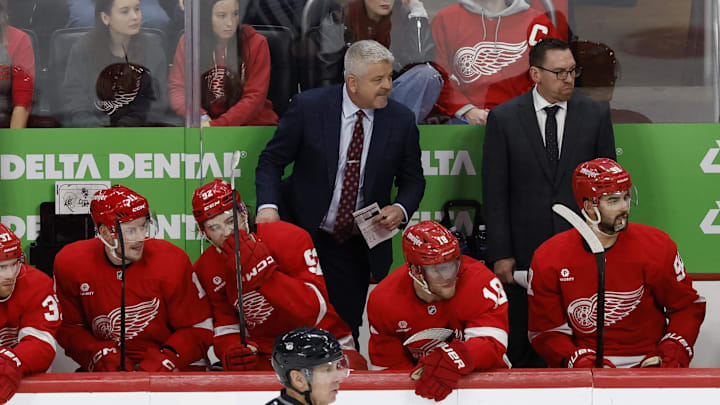 Dec 27, 2024; Detroit, Michigan, USA;  Detroit Red Wings head coach Todd McLellan  (center) stands on the bench in the third period against the Toronto Maple Leafs at Little Caesars Arena. Mandatory Credit: Rick Osentoski-Imagn Images
