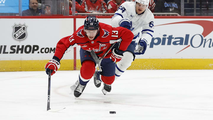 Nov 13, 2024; Washington, District of Columbia, USA; Washington Capitals left wing Jakub Vrana (13) dives for the puck in front of Toronto Maple Leafs center David Kampf (64) in the second period at Capital One Arena. Mandatory Credit: Geoff Burke-Imagn Images