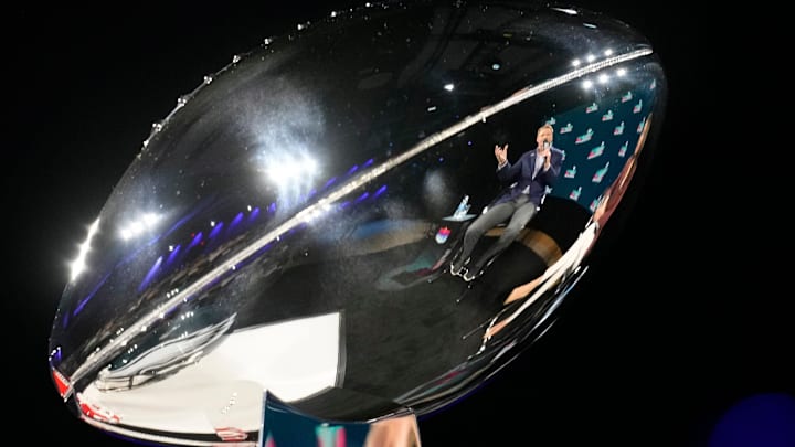 NFL commissioner Roger Goodell is reflected in the Vince Lombardi Trophy.