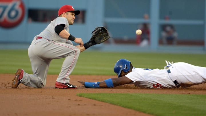 May 27, 2014; Los Angeles, CA, USA; Cincinnati Reds second baseman Skip Schumaker (25) tags out Los Angeles Dodgers right fielder Yasiel Puig (66) on a stolen base attempt in the first inning at Dodger Stadium. Mandatory Credit: Kirby Lee-Imagn Images