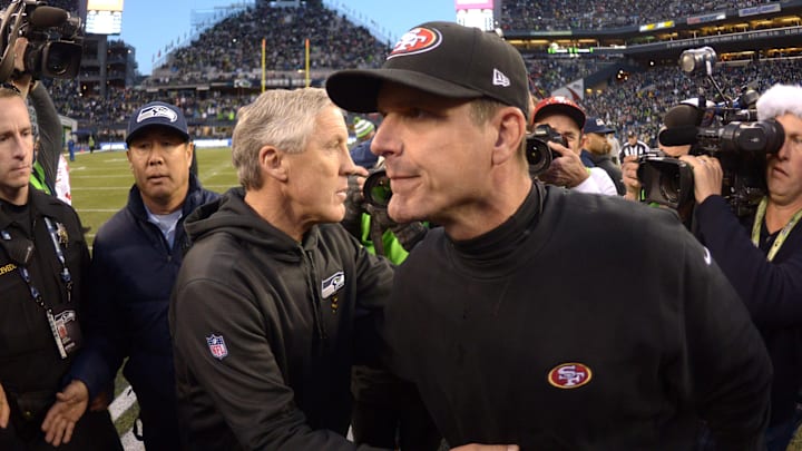 Dec 14, 2014; Seattle, WA, USA; Seattle Seahawks coach Pete Carroll (left) and San Francisco 49ers coach Jim Harbaugh shake hands after the game at CenturyLink Field. The Seahawks defeated the 49ers 17-7. Mandatory Credit: Kirby Lee-Imagn Images