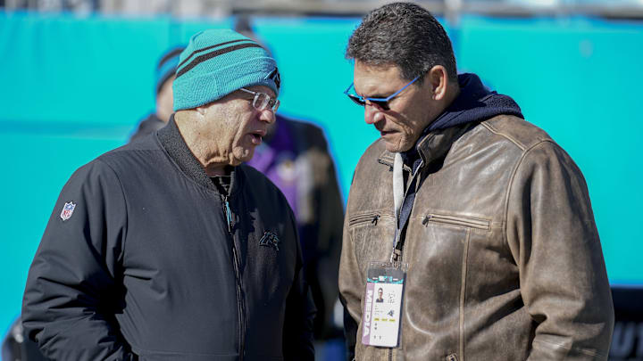 Dec 22, 2024; Charlotte, North Carolina, USA; Panthers owner David Tepper talks with former Panthers head coach Ron Rivera during pregame warmups at Bank of America Stadium. 