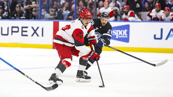 Mar 14, 2026; Tampa, Florida, USA; Carolina Hurricanes forward Seth Jarvis (24) handles the puck under pressure from Tampa Bay Lightning forward Zemgas Girgensons (28) in the second period at Benchmark International Arena. Mandatory Credit: Morgan Tencza-Imagn Images