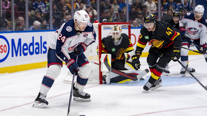 Dec 6, 2024; Vancouver, British Columbia, CAN; Vancouver Canucks defenseman Noah Juulsen (47) defends against Columbus Blue Jackets forward Mathieu Olivier (24) during the third period at Rogers Arena. Mandatory Credit: Bob Frid-Imagn Images