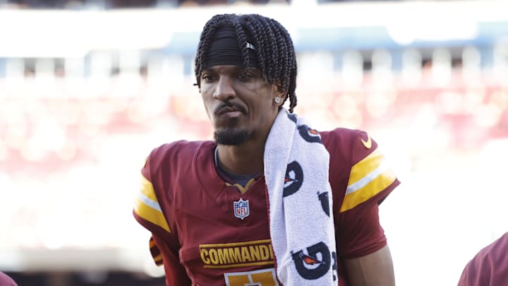 Washington Commanders quarterback Jayden Daniels walks off the field with trainers  after an injury against the Carolina Panthers