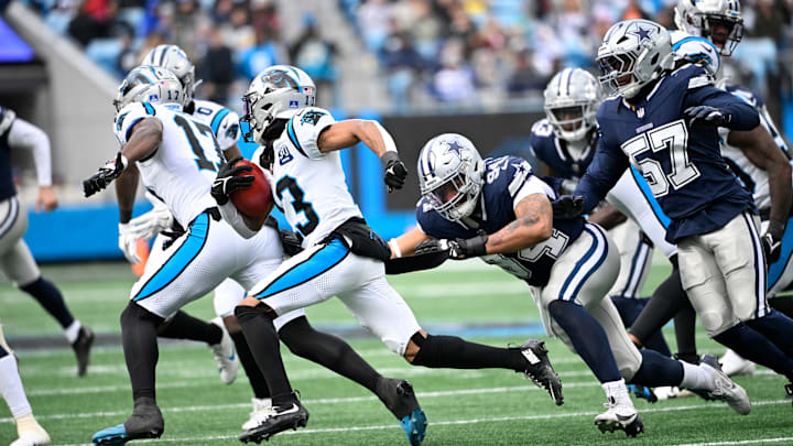 Dec 15, 2024; Charlotte, North Carolina, USA; Carolina Panthers wide receiver Deven Thompkins (13) with the ball as Dallas Cowboys defensive end Marshawn Kneeland (94) and linebacker Buddy Johnson (57) defend in the second quarter at Bank of America Stadium. Mandatory Credit: Bob Donnan-Imagn Images