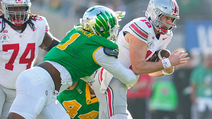 Ohio State Buckeyes quarterback Will Howard (18) runs through Oregon Ducks defensive end Jordan Burch (1) during the first half of the College Football Playoff quarterfinal at the Rose Bowl in Pasadena, Calif. on Jan. 1, 2025. Ohio State Buckeyes quarterback Will Howard (18) runs through Oregon Ducks defensive end Jordan Burch (1) during the first half of the College Football Playoff quarterfinal at the Rose Bowl in Pasadena, Calif. on Jan. 1, 2025.