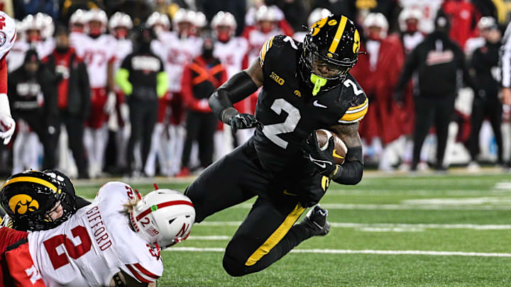 Nov 29, 2024; Iowa City, Iowa, USA; Iowa Hawkeyes running back Kaleb Johnson (2) runs the ball as Nebraska Cornhuskers defensive back Isaac Gifford (2) makes the tackle during the third quarter at Kinnick Stadium. Mandatory Credit: Jeffrey Becker-Imagn Images