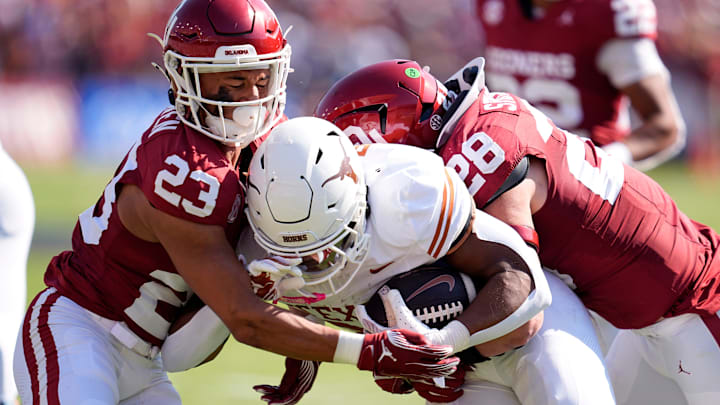 Texas Longhorns running back Jaydon Blue (23) tackled by Oklahoma Sooners defensive back Eli Bowen (23) and Danny Stutsman (28) in the first half of the Red River Rivalry, Oct., 12, 2024, in Arlington, Texas.