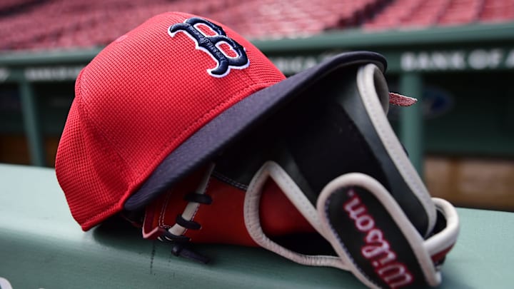 May 18, 2025; Boston, Massachusetts, USA;  A Boston Red Sox hat and glove rests on the railing by the dugout prior to a game against the Atlanta Braves at Fenway Park. Mandatory Credit: Bob DeChiara-Imagn Images