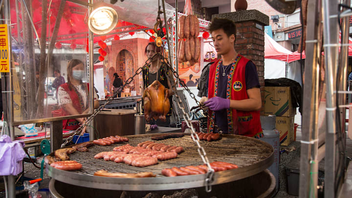 A man prepares some traditional Aboriginal barbecue pork and...
