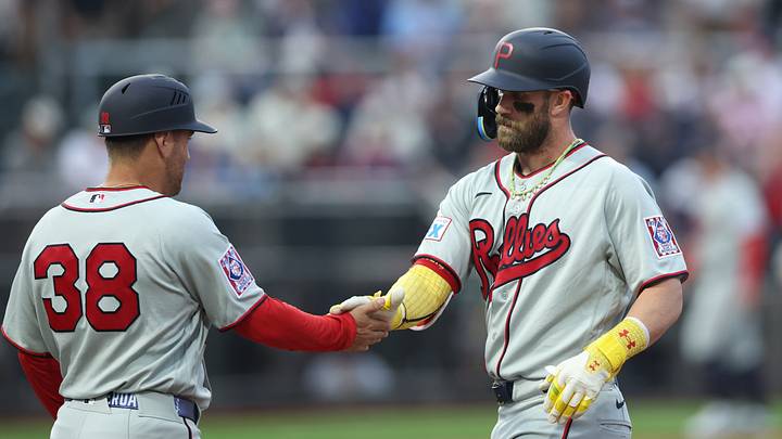 Aug 13, 2026; Dyersville, Iowa, USA; Philadelphia Phillies first baseman Bryce Harper (3) celebrates with first base coach Paco Figueroa (38) after getting a base hit against the Minnesota Twins at the Field of Dreams. Mandatory Credit: Reese Strickland-Imagn Images