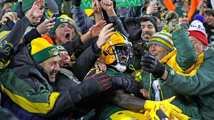 Green Bay Packers wide receiver Jayden Reed (11) celebrates with a Lambeau Leap after scoring a touchdown against the Dolphins.