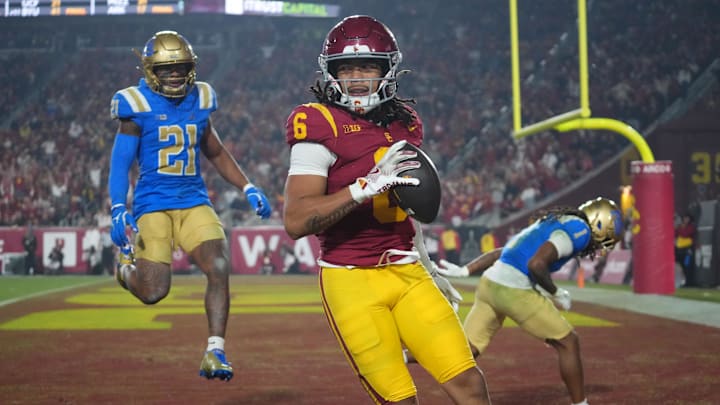 Nov 29, 2025; Los Angeles, California, USA; Southern California Trojans wide receiver Makai Lemon (6) catches a 32-yard touchdown pass against UCLA Bruins defensive back Kanye Clark (1) in the second half at United Airlines Field at Los Angeles Memorial Coliseum. Mandatory Credit: Kirby Lee-Imagn Images