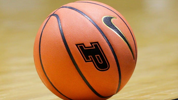 An NCAA basketball with the Purdue University logo sits on the court