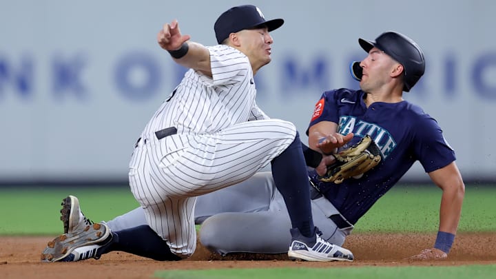 Jul 10, 2025; Bronx, New York, USA; New York Yankees shortstop Anthony Volpe (11) tags out Seattle Mariners right fielder Dominic Canzone (8) trying to steal second base during the eighth inning at Yankee Stadium. Mandatory Credit: Brad Penner-Imagn Images