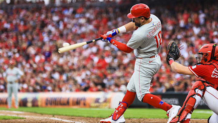 Aug 11, 2025; Cincinnati, Ohio, USA; Philadelphia Phillies designated hitter Kyle Schwarber (12) hits a two-run home run in the eighth inning against the Cincinnati Reds at Great American Ball Park. Mandatory Credit: Katie Stratman-Imagn Images