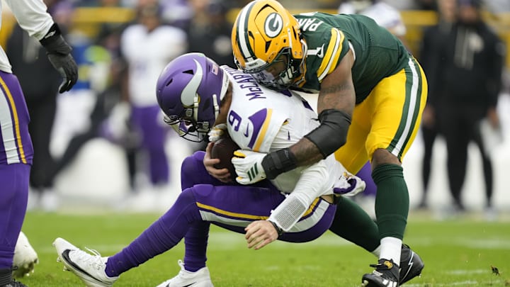 Nov 23, 2025; Green Bay, Wisconsin, USA; Minnesota Vikings quarterback J.J. McCarthy (9) is sacked by Green Bay Packers defensive end Micah Parsons (1) during the second half at Lambeau Field. Mandatory Credit: Kayla Wolf-Imagn Images