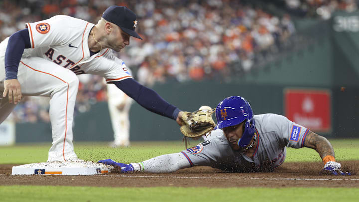 New York Mets center fielder Jose Siri (19) is safe as Houston Astros first baseman Christian Walker (8) attempts to apply a tag on a throw to first during the sixth inning at Daikin Park.