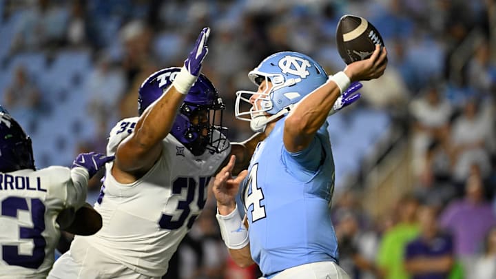 Sep 1, 2025; Chapel Hill, North Carolina, USA; North Carolina Tar Heels quarterback Max Johnson (14) passes the ball as TCU Horned Frogs defensive tackle Tristan Johnson (35) pressures in the third quarter at Kenan Stadium. Mandatory Credit: Bob Donnan-Imagn Images