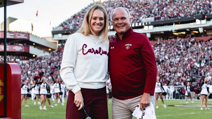 New softball coach Ashley Chastain Woodard with new baseball coach Paul Mainieri at a Gamecock football game.