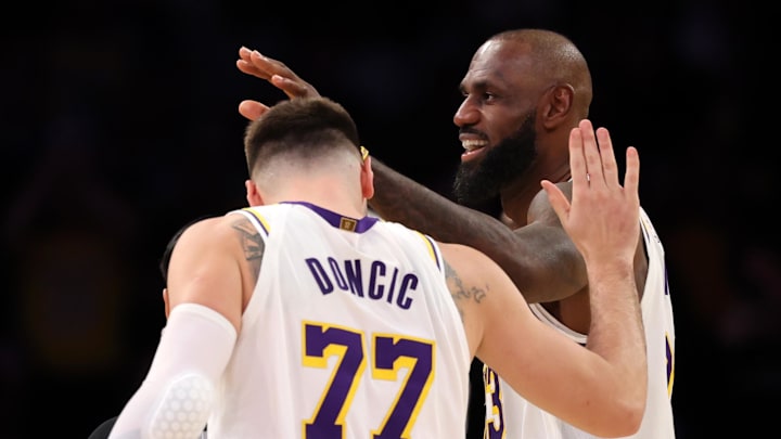 Jan 4, 2026; Los Angeles, California, USA;  Los Angeles Lakers forward LeBron James (right) is greeted by forward Luka Doncic (77) after making a basket during the fourth quarter against the Memphis Grizzlies at Crypto.com Arena. Mandatory Credit: Kiyoshi Mio-Imagn Images