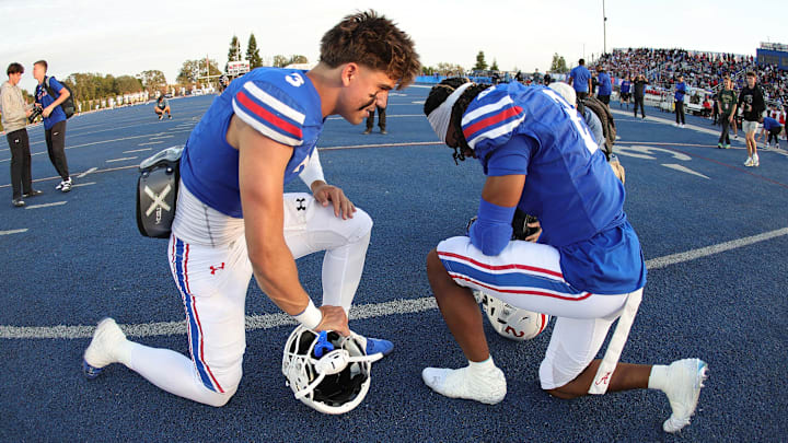 Folsom QB Ryder Lyons, left, prays pregame with teammate Jameson Powell.