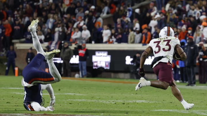 Nov 25, 2023; Charlottesville, Virginia, USA; Virginia Tech Hokies running back Bhayshul Tuten (33) carries the ball past Virginia Cavaliers cornerback Sam Westfall (13) during the third quarter at Scott Stadium. Mandatory Credit: Geoff Burke-USA TODAY Sports Nov 25, 2023; Charlottesville, Virginia, USA; Virginia Tech Hokies running back Bhayshul Tuten (33) carries the ball past Virginia Cavaliers cornerback Sam Westfall (13) during the third quarter at Scott Stadium. Mandatory Credit: Geoff Burke-USA TODAY Sports