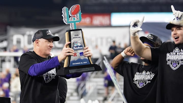 Dec 26, 2024; Phoenix, AZ, USA; Kansas State Wildcats head coach Chris Klieman celebrates with the trophy after defeating the Rutgers Scarlet Knights during the Rate Bowl at Chase Field. Mandatory Credit: Mark J. Rebilas-Imagn Images