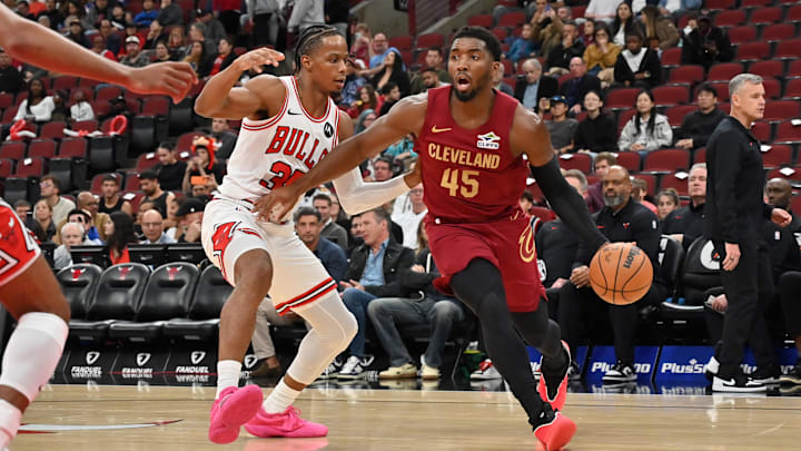 Oct 9, 2025; Chicago, Illinois, USA; Cleveland Cavaliers guard Donovan Mitchell (45) drives against Chicago Bulls forward/guard Isaac Okoro (35) during the first half at United Center. Mandatory Credit: Patrick Gorski-Imagn Images