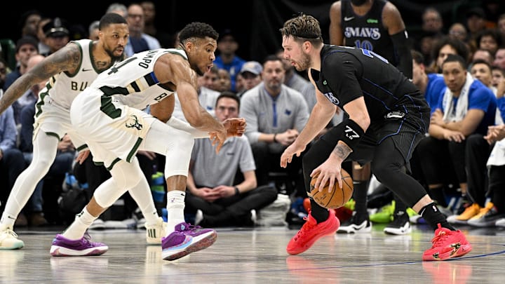 Feb 3, 2024; Dallas, Texas, USA; Dallas Mavericks guard Luka Doncic (77) looks to move the ball past Milwaukee Bucks guard Damian Lillard (0) and forward Giannis Antetokounmpo (34) during the second half at the American Airlines Center. Mandatory Credit: Jerome Miron-Imagn Images