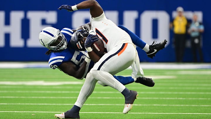 Aug 11, 2024; Indianapolis, Indiana, USA;  Indianapolis Colts linebacker Segun Olubi (50) tackles Denver Broncos running back Audric Estime (37) during the second quarter at Lucas Oil Stadium. Mandatory Credit: Marc Lebryk-Imagn Images