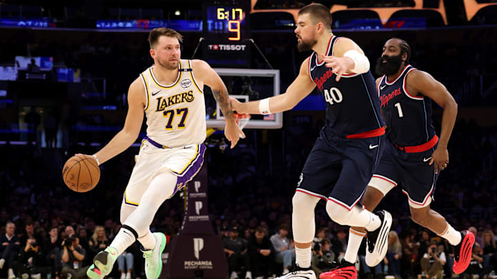 Mar 2, 2025; Los Angeles, California, USA; Los Angeles Lakers guard Luka Doncic (77) dribbles against LA Clippers center Ivica Zubac (40) and guard James Harden (1) during the second quarter at Crypto.com Arena. Mandatory Credit: Jason Parkhurst-Imagn Images