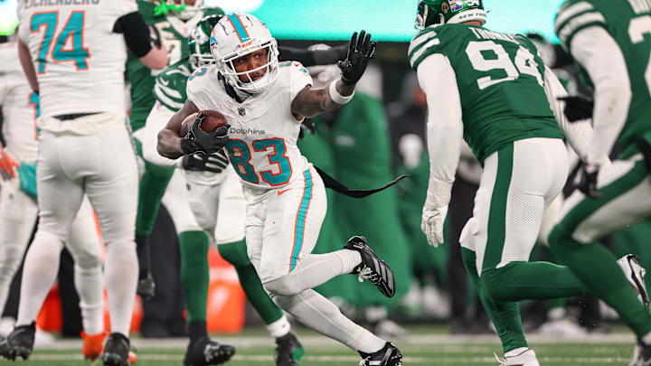 Miami Dolphins wide receiver Malik Washington (83) gains yards after catch as New York Jets defensive end Solomon Thomas (94) pursues during the second half at MetLife Stadium in the 2024 season finale.