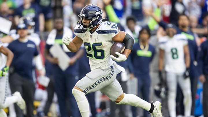 Dec 8, 2024; Glendale, Arizona, USA; Seattle Seahawks running back Zach Charbonnet (26) runs for a touchdown against the Arizona Cardinals in the first half at State Farm Stadium. Mandatory Credit: Mark J. Rebilas-Imagn Images