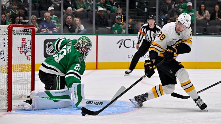 Oct 20, 2026; Dallas, Texas, USA; Dallas Stars goaltender Jake Oettinger (29) stops a backhand shot by Boston Bruins center Morgan Geekie (39) during the first period at the American Airlines Center. Mandatory Credit: Jerome Miron-Imagn Images