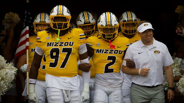 Sep 14, 2024; Columbia, Missouri, USA; Missouri Tigers defensive lineman Eddie Kelly Jr. (97), cornerback Toriano Pride Jr. (2) and coach Eli Drinkwitz link arms prior to a game against the Vanderbilt Commodores as they walk out of the tunnel at Faurot Field at Memorial Stadium.