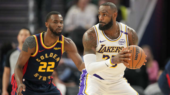 Jan 25, 2025; San Francisco, California, USA; Los Angeles Lakers forward LeBron James (right) handles the ball against Golden State Warriors forward Andrew Wiggins (22) during the third quarter at Chase Center. Mandatory Credit: Darren Yamashita-Imagn Images