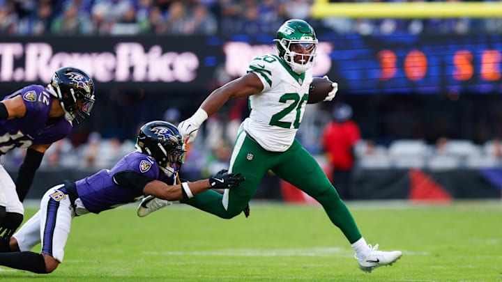 Nov 23, 2025; Baltimore, Maryland, USA;  New York Jets running back Breece Hall (20) rushes as Baltimore Ravens cornerback Nate Wiggins (2) defends during the fourth quarter at M&T Bank Stadium. Mandatory Credit: Peter Casey-Imagn Images